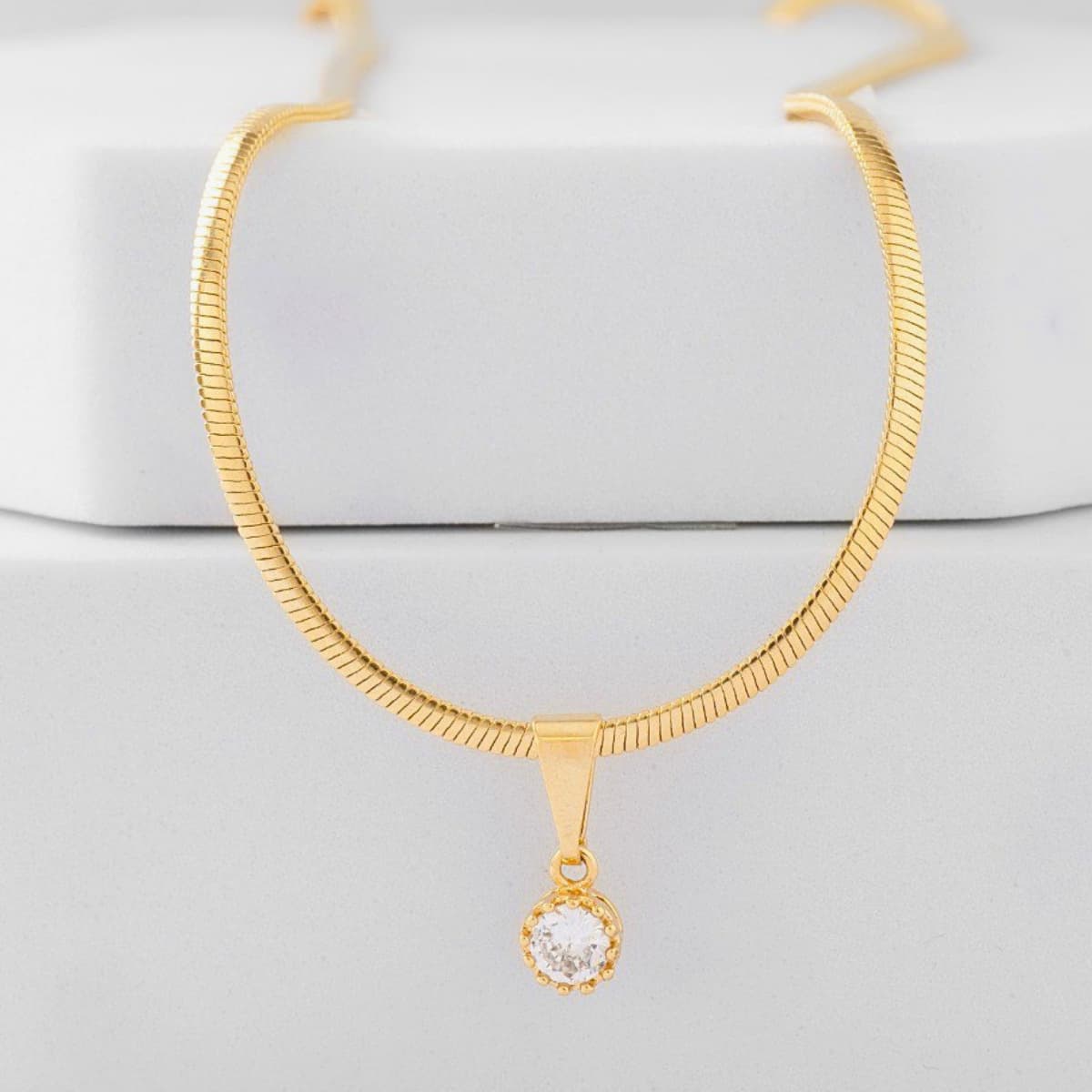 Cadena serpiente con dije de piedra verde en cuello de mujer